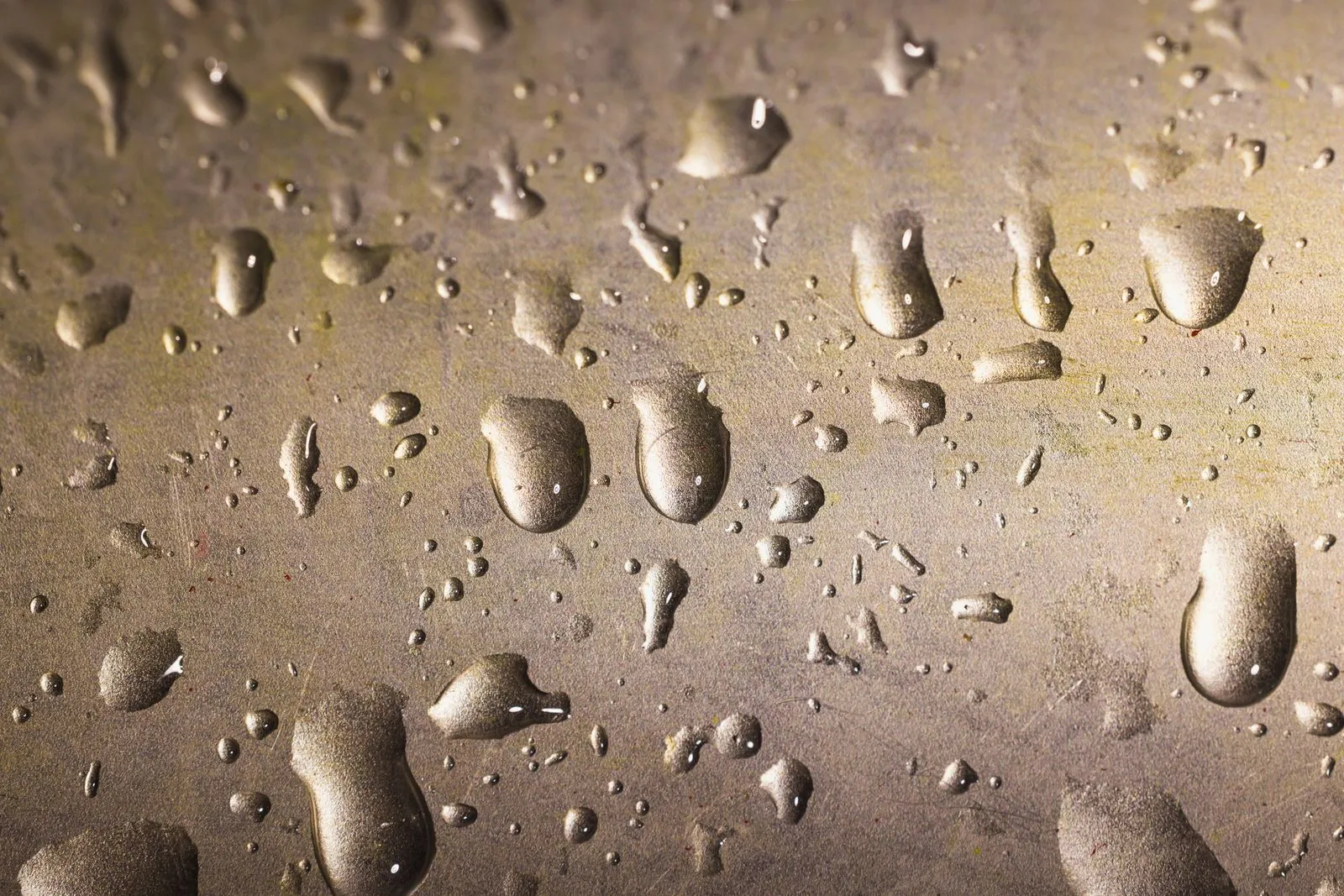 Condensation droplets beading on a cold metal panel inside a building